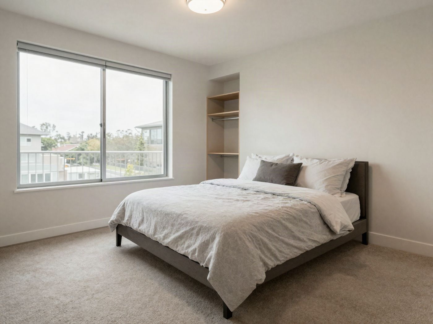 A bedroom with a large window and a walk-in closet door
